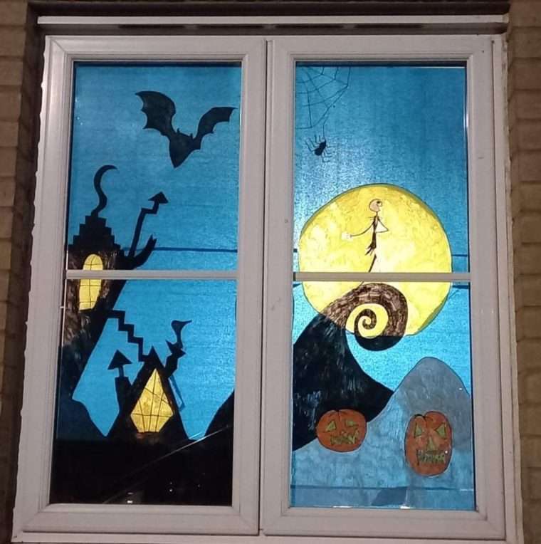 Photo of a window which has been decorated with tissue paper to create a scene from the Nightmare before Christmas.