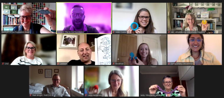 Zoom screenshot of participants smiling and holding up various coloured playdough sculptures.